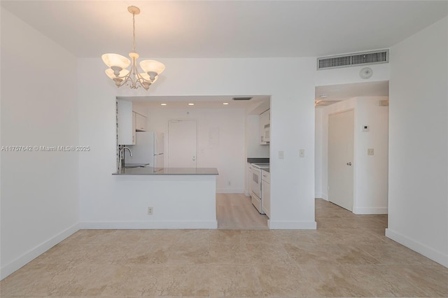 kitchen with white appliances, visible vents, a chandelier, white cabinetry, and a sink