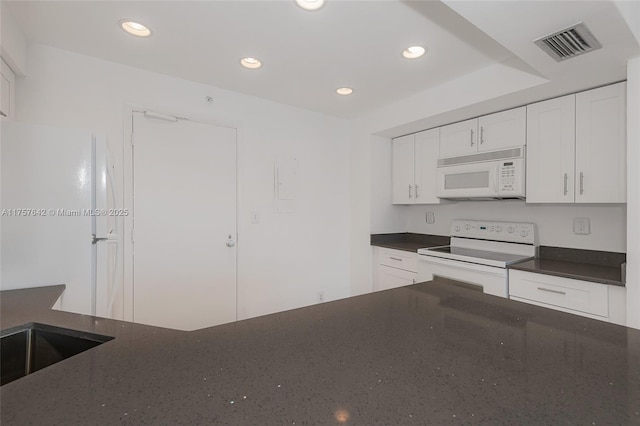 kitchen featuring white appliances, recessed lighting, visible vents, and white cabinets