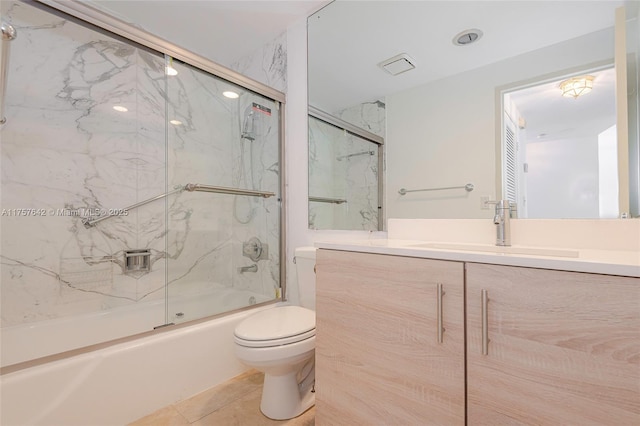 full bathroom with bath / shower combo with glass door, visible vents, toilet, vanity, and tile patterned flooring