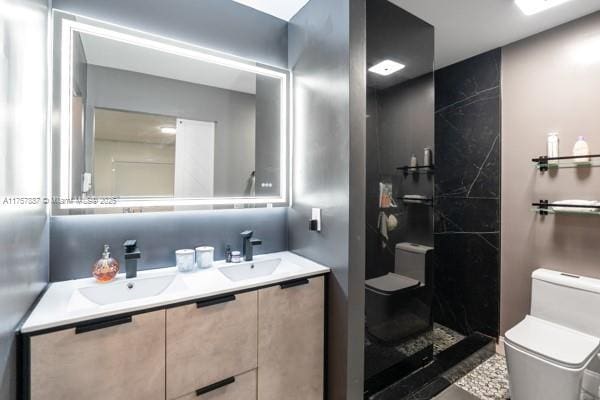 full bathroom with double vanity, tiled shower, toilet, and a sink