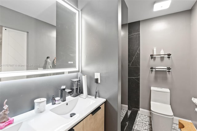 bathroom with baseboards, toilet, and vanity