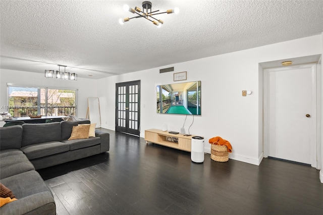 living area with baseboards, visible vents, an inviting chandelier, dark wood-style flooring, and a textured ceiling