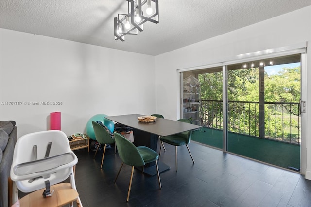 dining space with a textured ceiling and wood finished floors