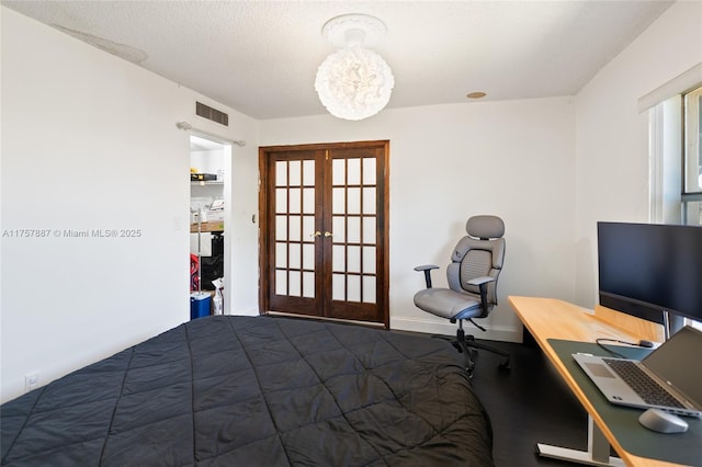 bedroom featuring a textured ceiling, french doors, visible vents, and baseboards