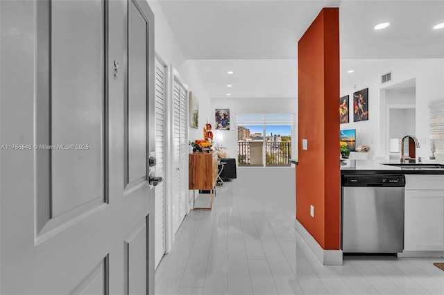 hallway featuring visible vents, baseboards, a sink, and recessed lighting