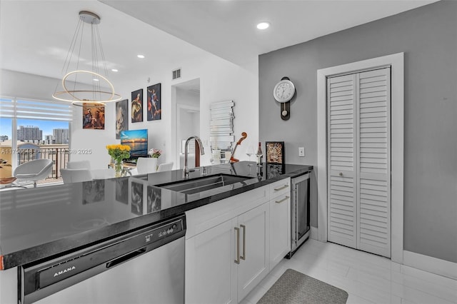 kitchen featuring visible vents, white cabinets, a sink, pendant lighting, and stainless steel dishwasher