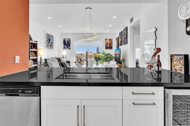 kitchen with wine cooler, stainless steel dishwasher, open floor plan, white cabinets, and a sink