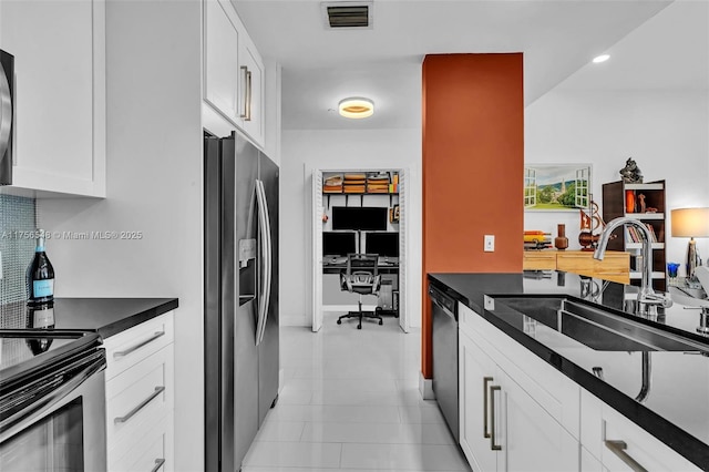 kitchen featuring dark countertops, stainless steel refrigerator with ice dispenser, a sink, and visible vents