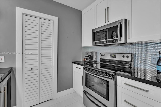 kitchen with stainless steel appliances, dark countertops, white cabinetry, and decorative backsplash