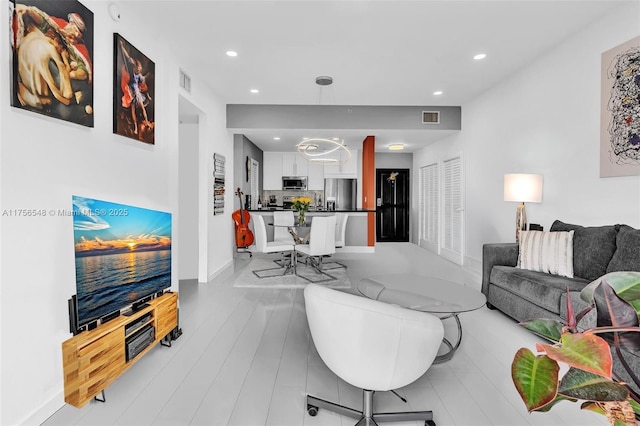 living room featuring light wood-type flooring, recessed lighting, visible vents, and baseboards