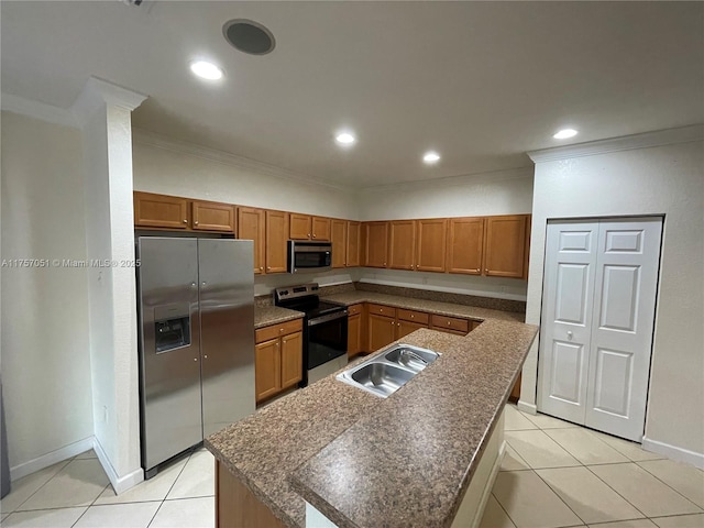 kitchen with brown cabinetry, light tile patterned floors, stainless steel appliances, and a sink