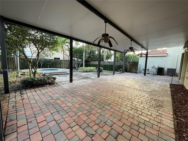 view of patio with an in ground hot tub, a fenced backyard, and a ceiling fan