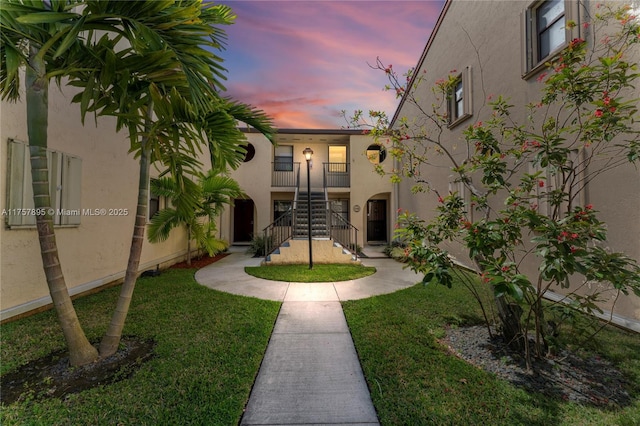 yard at dusk featuring stairway