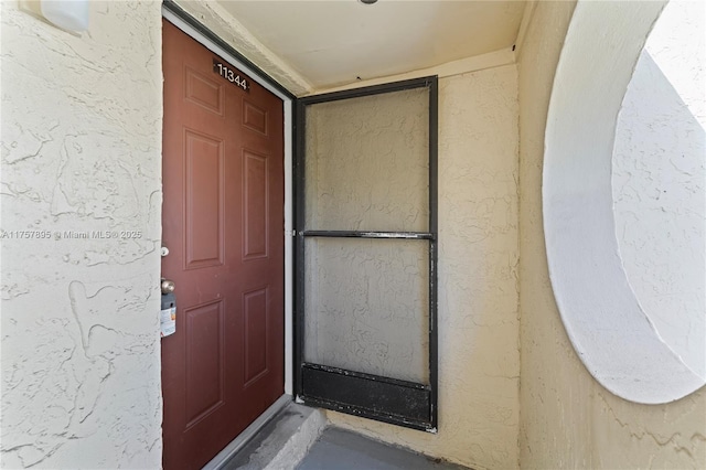 entrance to property featuring stucco siding