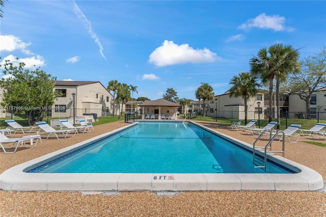 community pool featuring a patio, fence, and a residential view