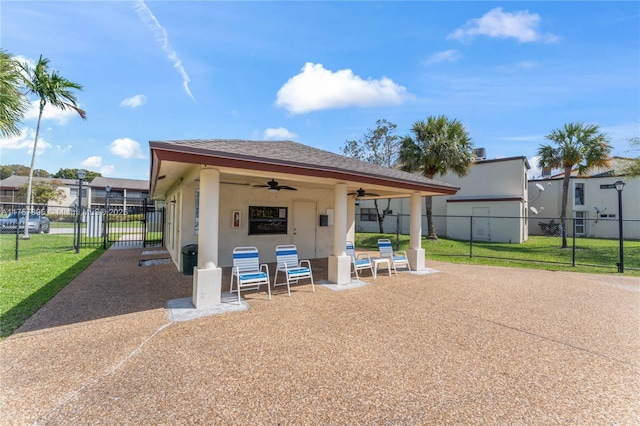 exterior space featuring a gate, fence, and ceiling fan