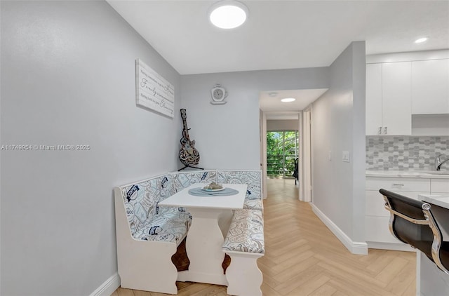 bathroom featuring baseboards and decorative backsplash