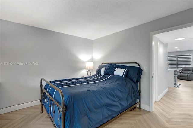 bedroom featuring a textured ceiling and baseboards