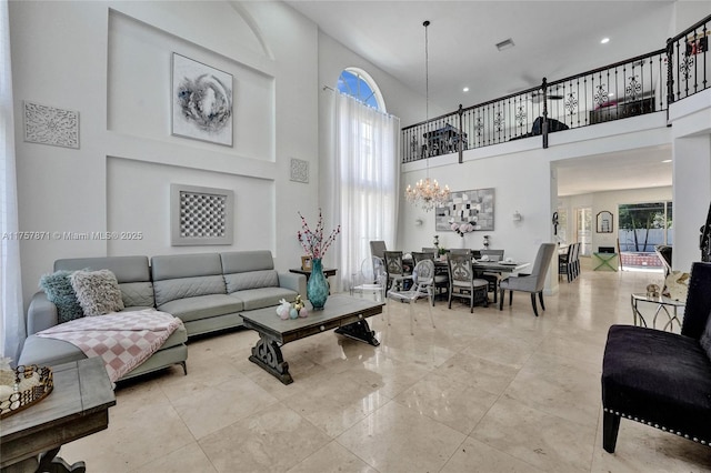 living room with a chandelier, visible vents, and a towering ceiling