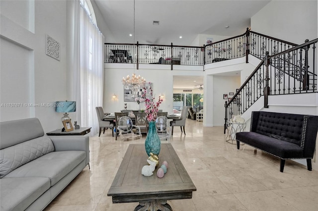 living area with stairs, a towering ceiling, and a notable chandelier