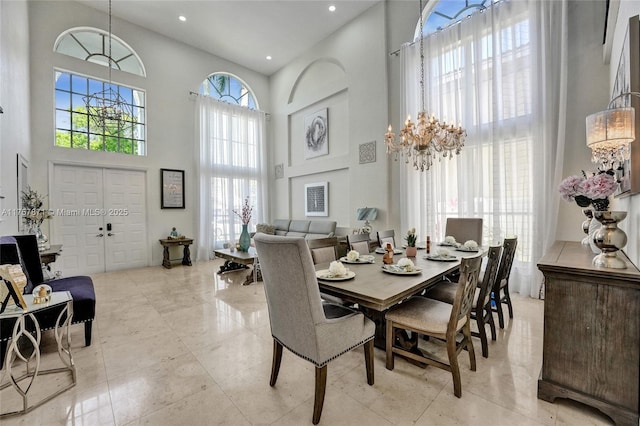 dining area featuring recessed lighting, a towering ceiling, and a notable chandelier