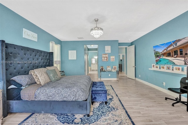 bedroom featuring visible vents, baseboards, and wood finished floors