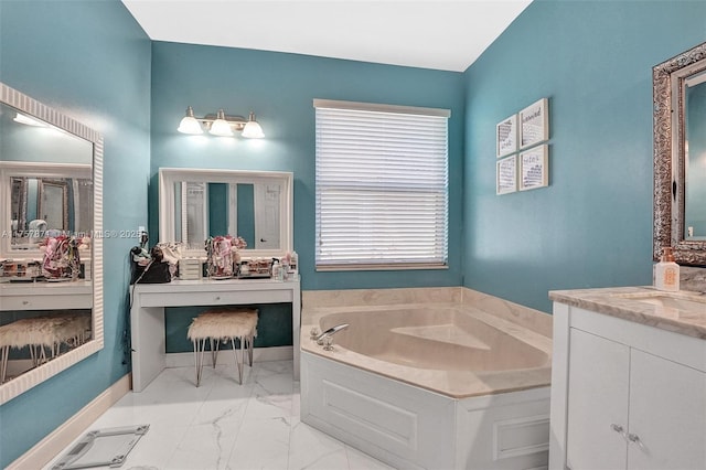 bathroom with marble finish floor, baseboards, a bath, and vanity