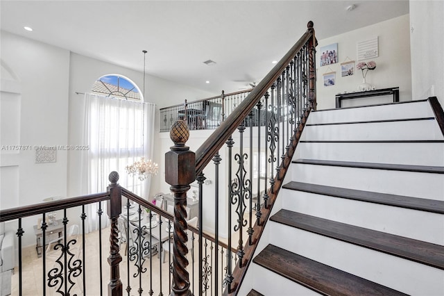 stairway featuring recessed lighting and an inviting chandelier