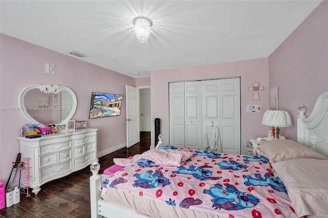 bedroom featuring baseboards, a closet, visible vents, and wood finished floors