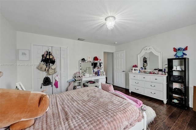 bedroom with a closet, visible vents, and dark wood-type flooring