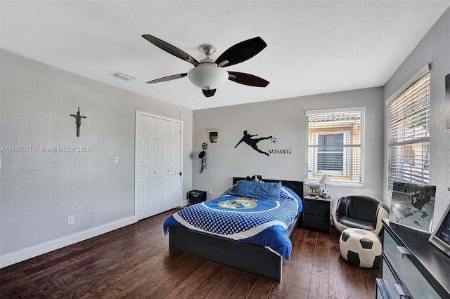 bedroom with a ceiling fan, visible vents, baseboards, a closet, and wood-type flooring