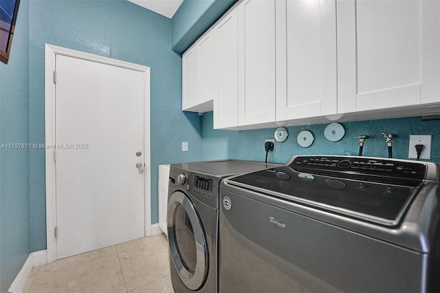 washroom featuring cabinet space, light tile patterned floors, baseboards, and independent washer and dryer