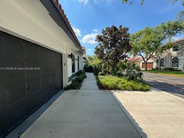 view of side of property featuring stucco siding and driveway