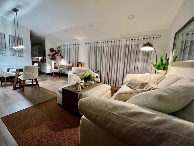 living area with vaulted ceiling and wood finished floors