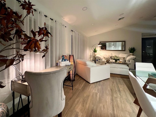 living room with lofted ceiling, wood finished floors, and visible vents