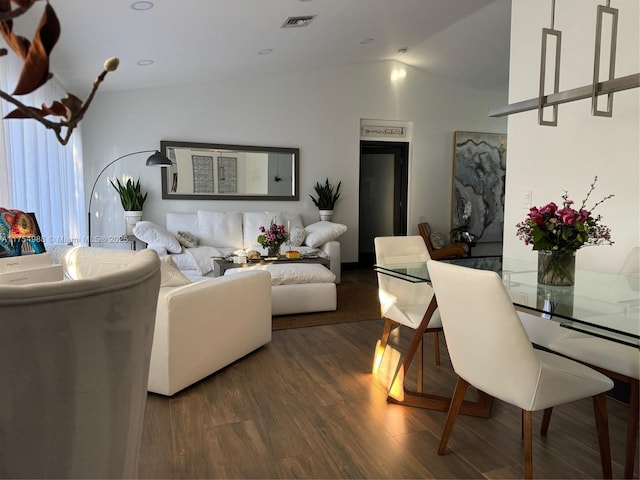 living room with lofted ceiling, wood finished floors, and visible vents