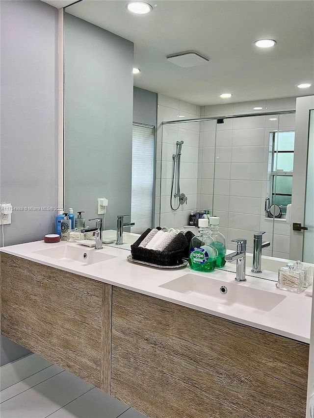 bathroom featuring double vanity, recessed lighting, a stall shower, and a sink