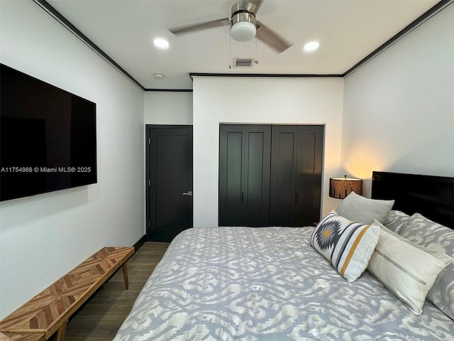 bedroom with crown molding, recessed lighting, wood finished floors, and a closet