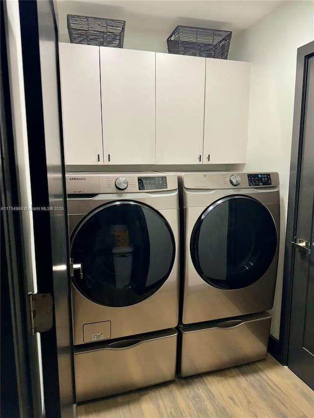 3548 Sahara Springs Blvd, Pompano Beach, FL 33069 - laundry area featuring washer and dryer, cabinet space, and light wood-style flooring