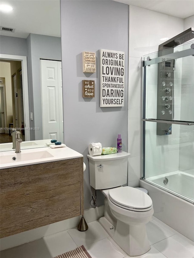 bathroom featuring vanity, visible vents, tile patterned floors, toilet, and combined bath / shower with glass door