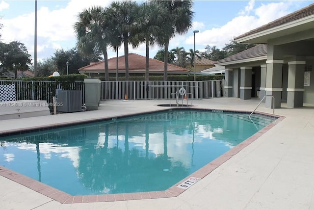 pool with a patio and fence