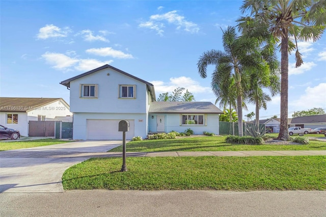 view of front of house featuring fence, driveway, a front lawn, and stucco siding