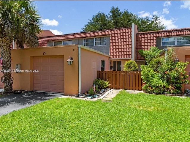 exterior space with a garage, a front yard, driveway, and stucco siding