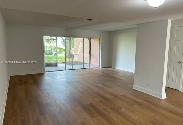 spare room featuring visible vents, baseboards, and wood finished floors