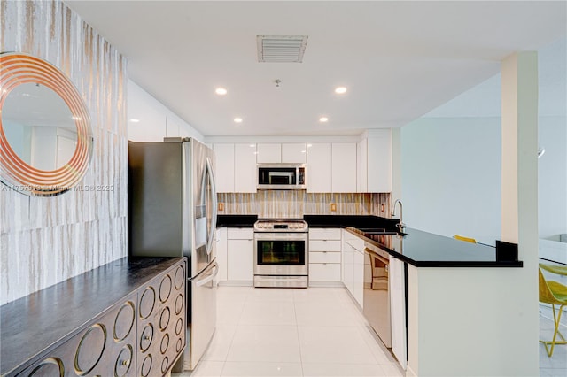 kitchen with stainless steel appliances, a sink, visible vents, dark countertops, and modern cabinets