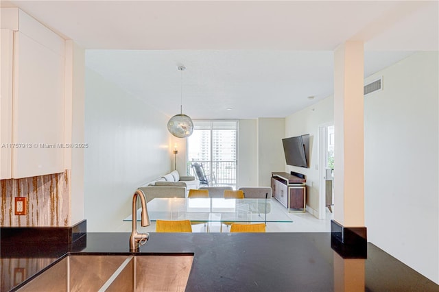 1250 S Miami Ave Unit 1109, Miami, FL 33130 - kitchen with dark countertops, visible vents, open floor plan, and white cabinets
