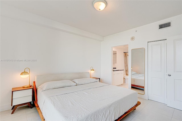 1250 S Miami Ave Unit 1109, Miami, FL 33130 - bedroom featuring visible vents, connected bathroom, and light tile patterned flooring