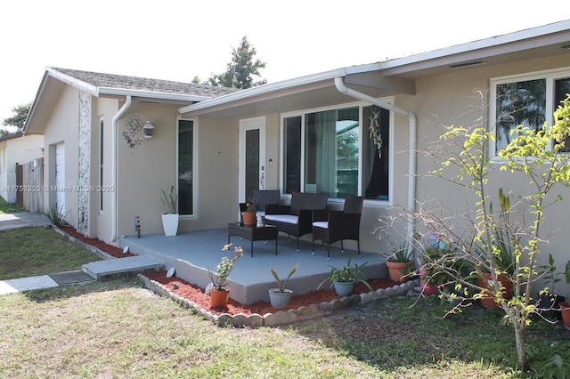 rear view of house featuring a porch and stucco siding