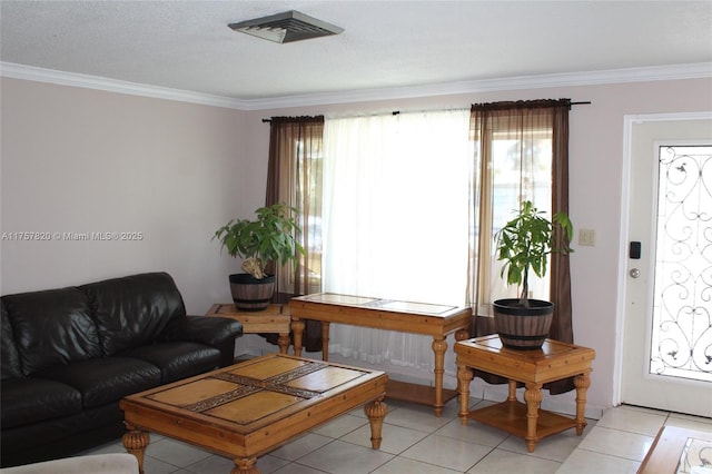 living area with a healthy amount of sunlight, light tile patterned floors, visible vents, and ornamental molding