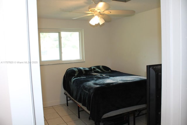 bedroom featuring a ceiling fan, baseboards, and light tile patterned floors